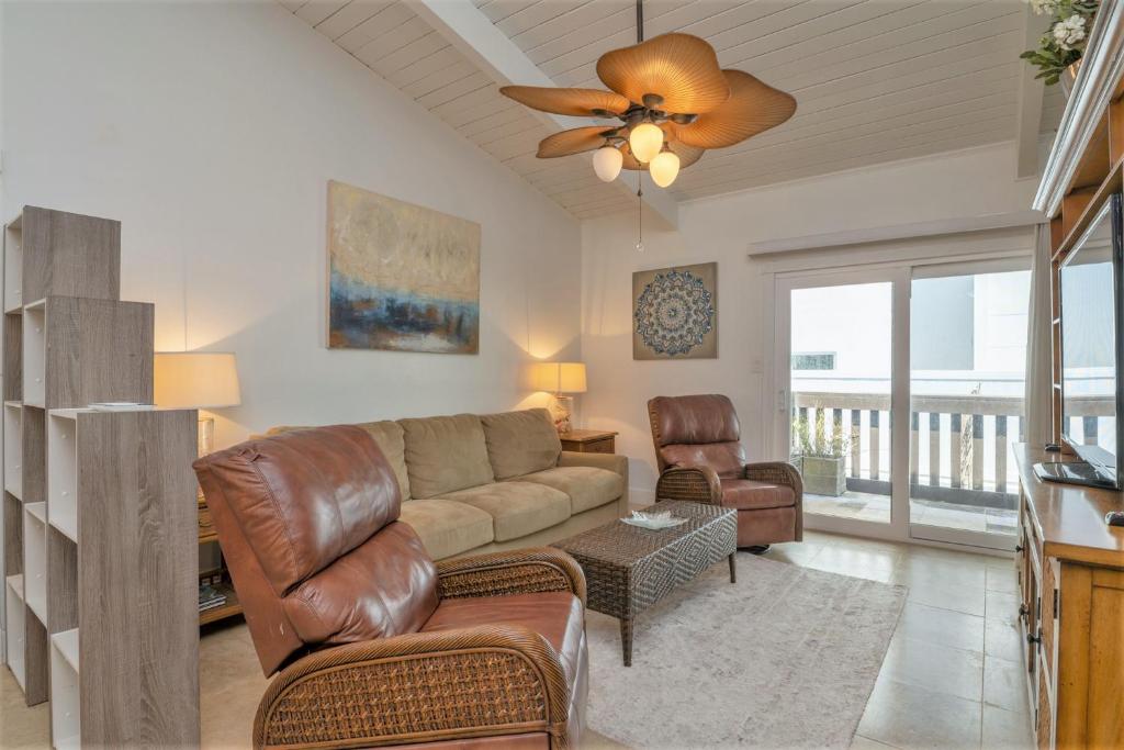 uma sala de estar com um sofá e uma ventoinha de tecto em Tiki 216 em South Padre Island