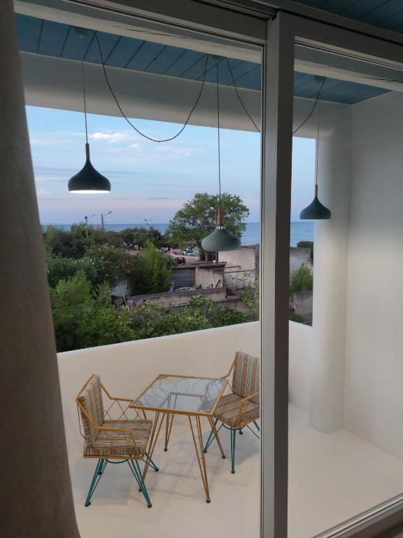 a balcony with a table and chairs and a view of the ocean at Casa Mediterranea Jacuzzi riscaldata con Caminetto in Specchiolla