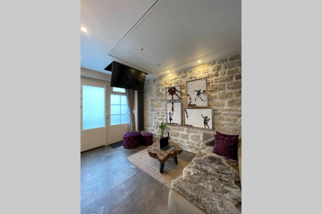 - un salon avec un canapé et un mur en briques dans l'établissement Tiny Gallery Paris Gare Montparnasse, à Paris