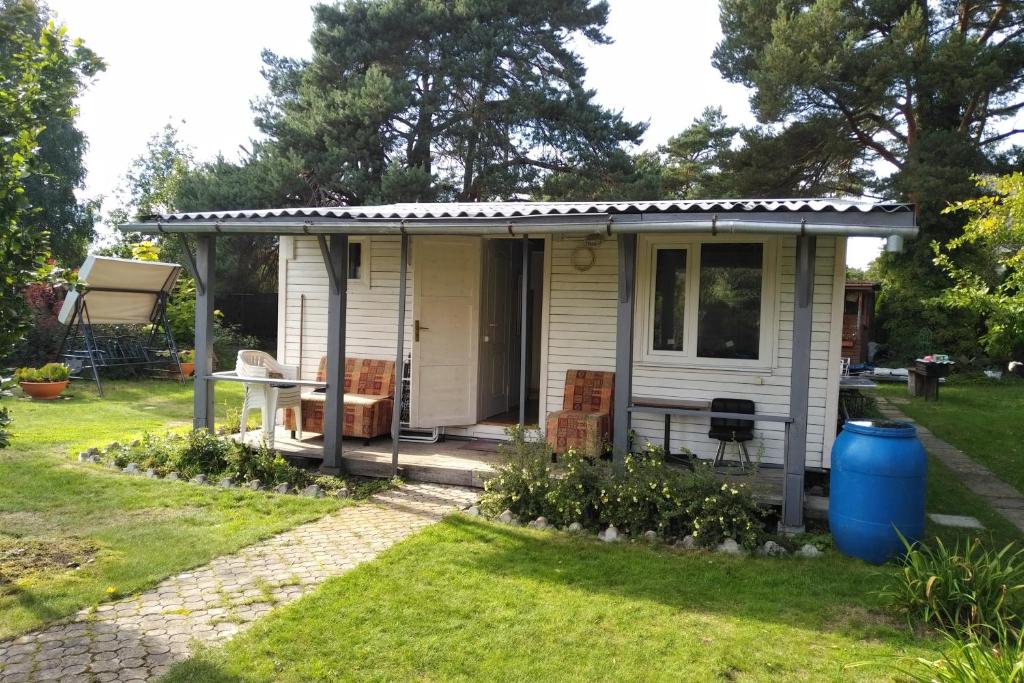 a small white house with a gazebo at Renovated wooden cottage 300 meters from the beach in Ragaciems