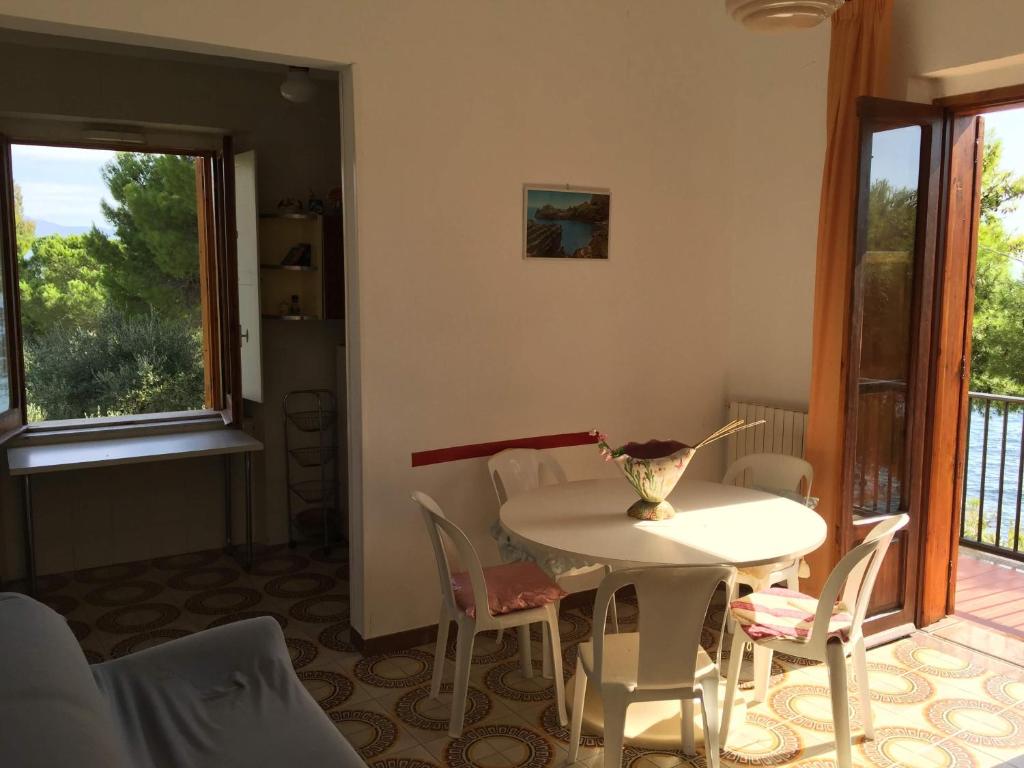una sala da pranzo con tavolo, sedie e finestra di Il mare fuori casa vacanze a Marina di Casalvelino