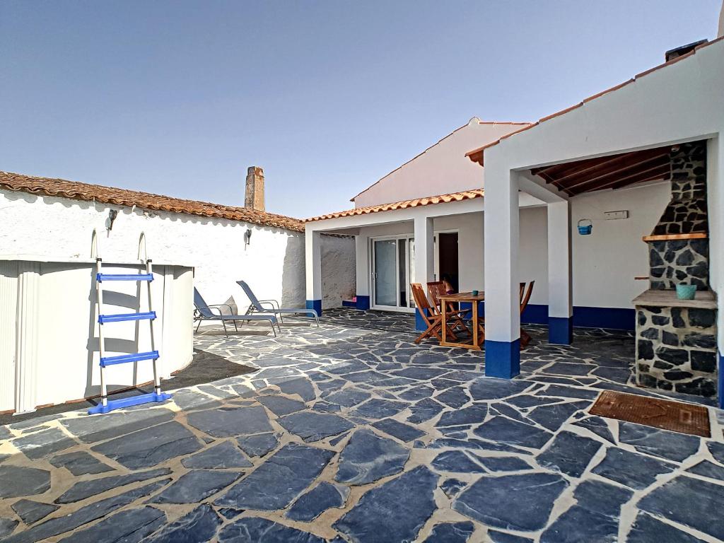 una casa con patio de piedra y chimenea en Casa Refugio Do Campo, en Reguengos de Monsaraz