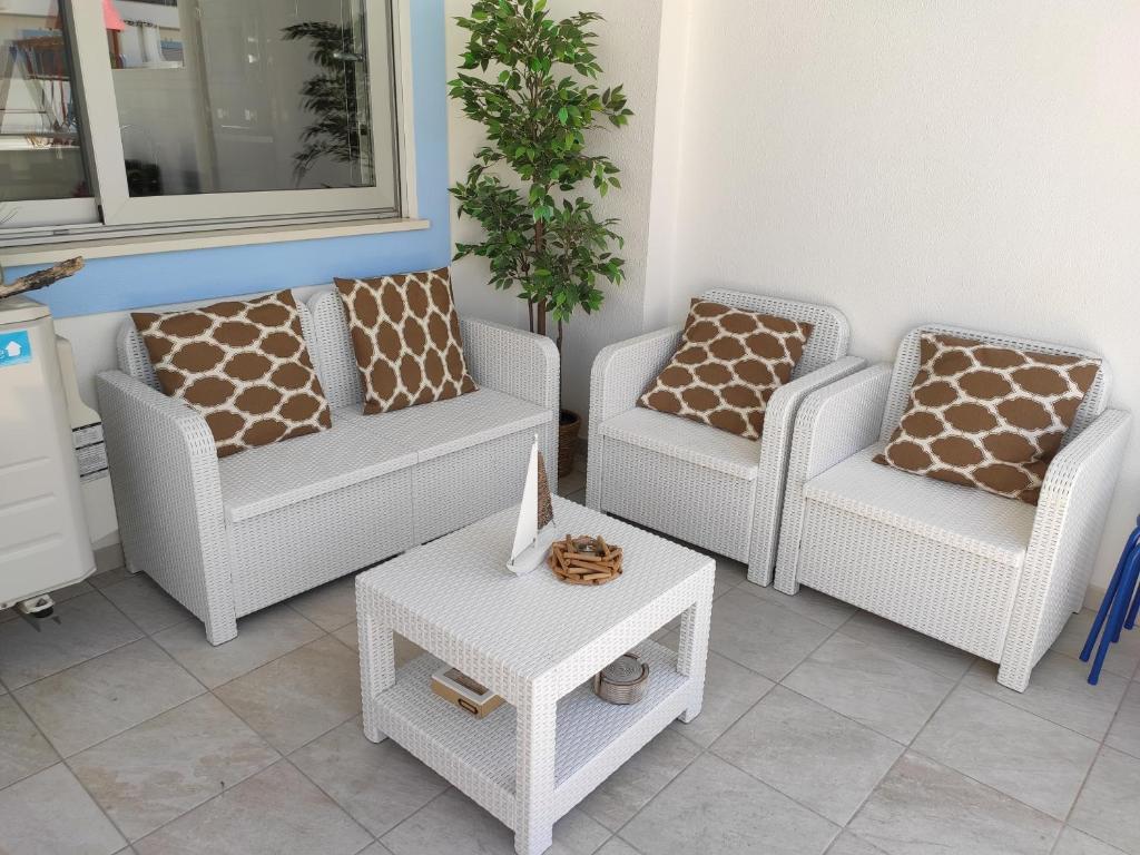 een woonkamer met 3 stoelen en een tafel bij Numar Residence J -Manta Rota in Manta Rota