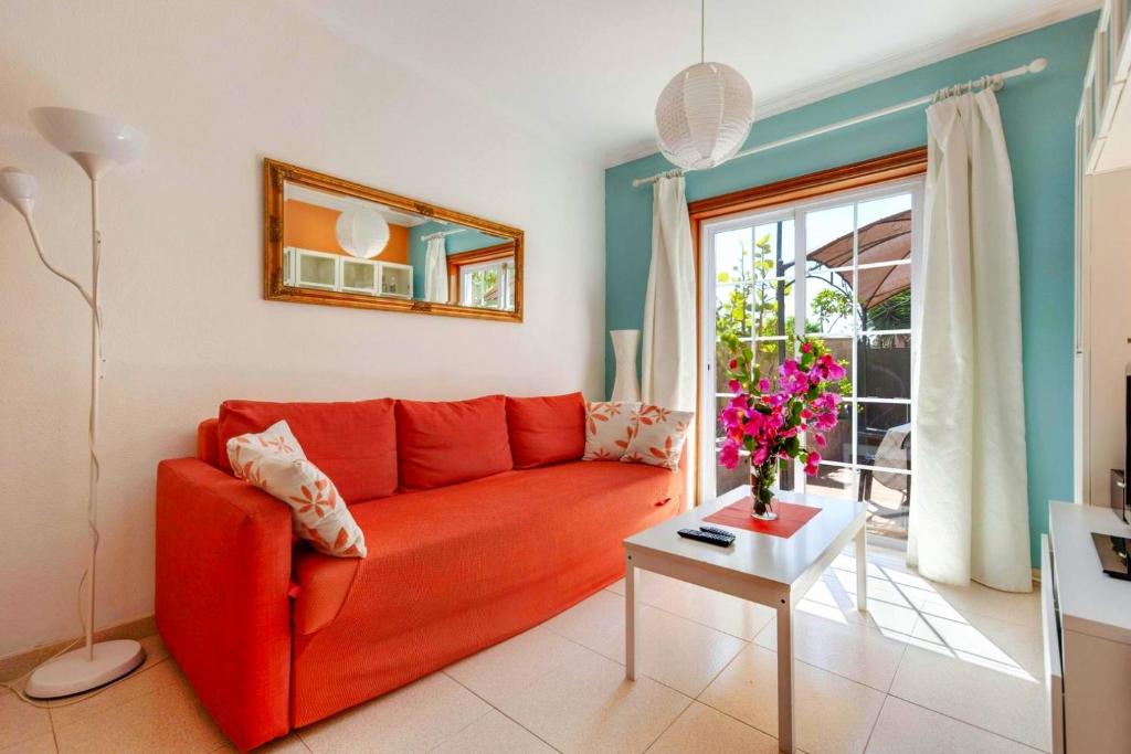 een woonkamer met een rode bank en een tafel bij Remarkable 2-Bed House in Arona in Arona