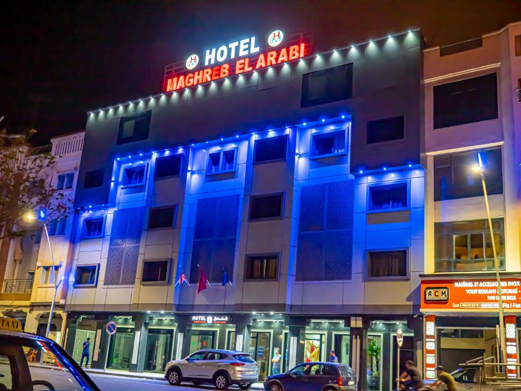 a hotel with a blue sign on the front of it at Hotel Maghreb El Arabi in Nador