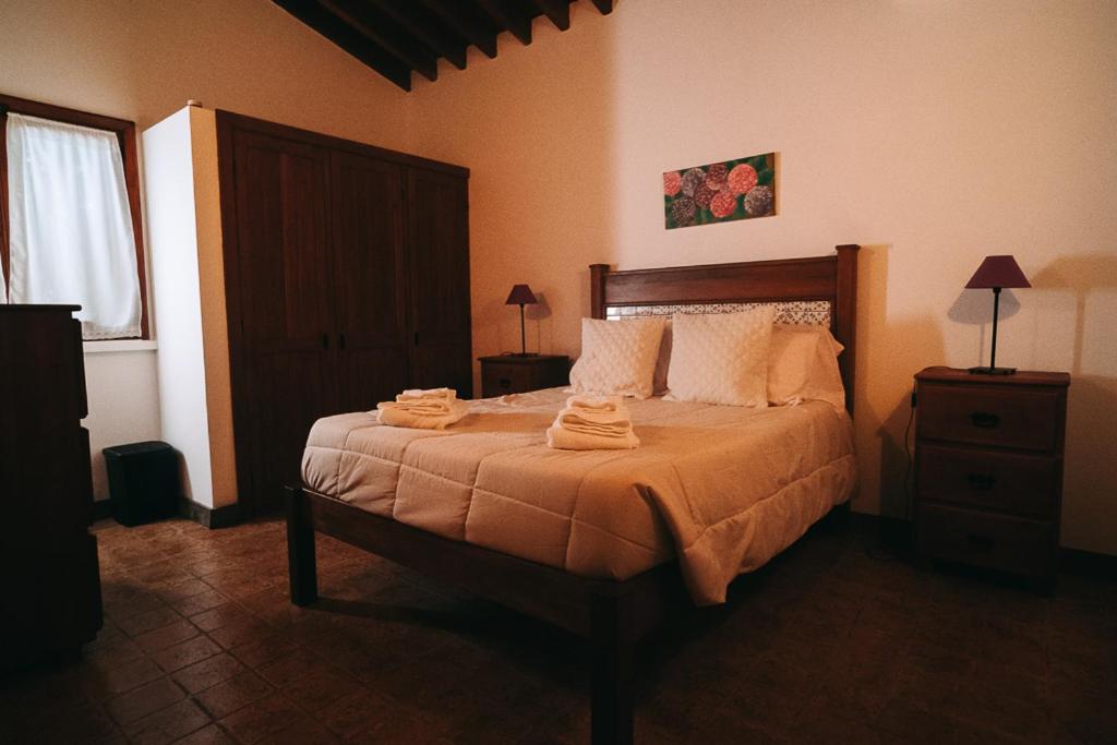 サン・ヴィセンテ・フェレイラにあるAzores Casa da Mataのベッドルーム1室(ベッド1台、タオル2枚付)