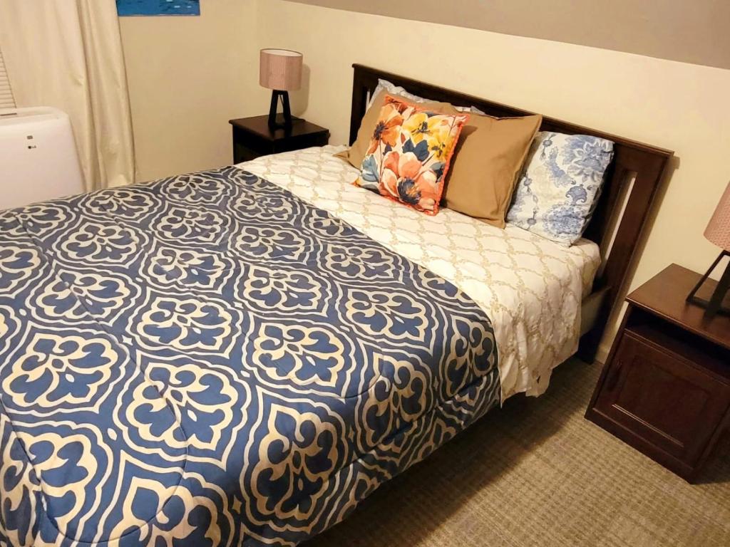 a bedroom with a blue and white bed with pillows at Delightful well located one bedroom attic in Elizabeth
