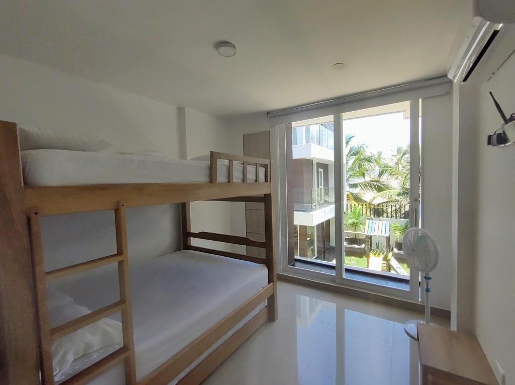 sypialnia z 2 łóżkami piętrowymi i oknem w obiekcie Loft 39 w mieście Coveñas