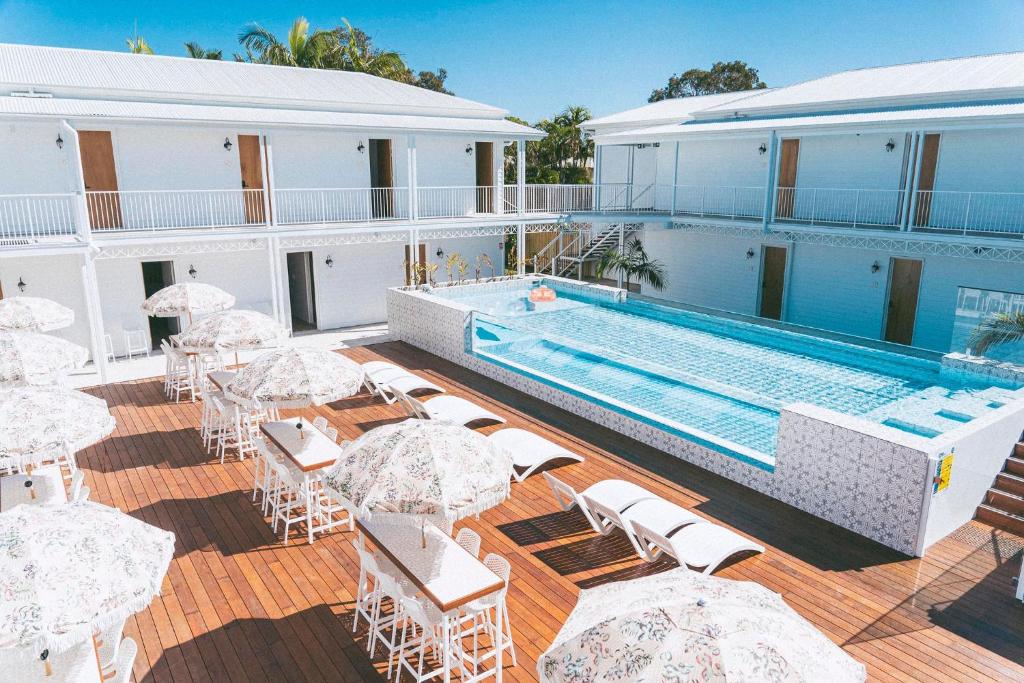 un complejo con piscina, mesas y sillas en Bounce Noosa en Noosaville