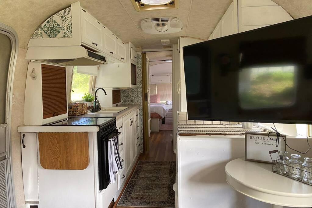 a kitchen with a large tv in a caravan at Amazing Airstream, Beaufort, SC-Enjoy the Journey in Beaufort