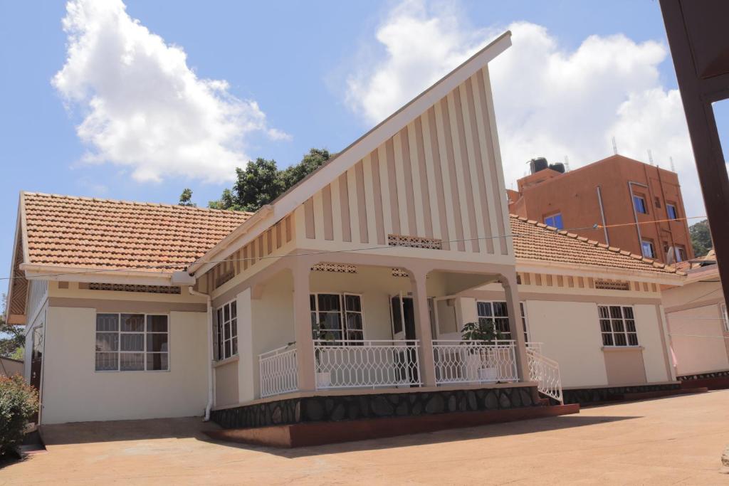 a white house with a balcony on a street at Luwafu Guest House in Kampala