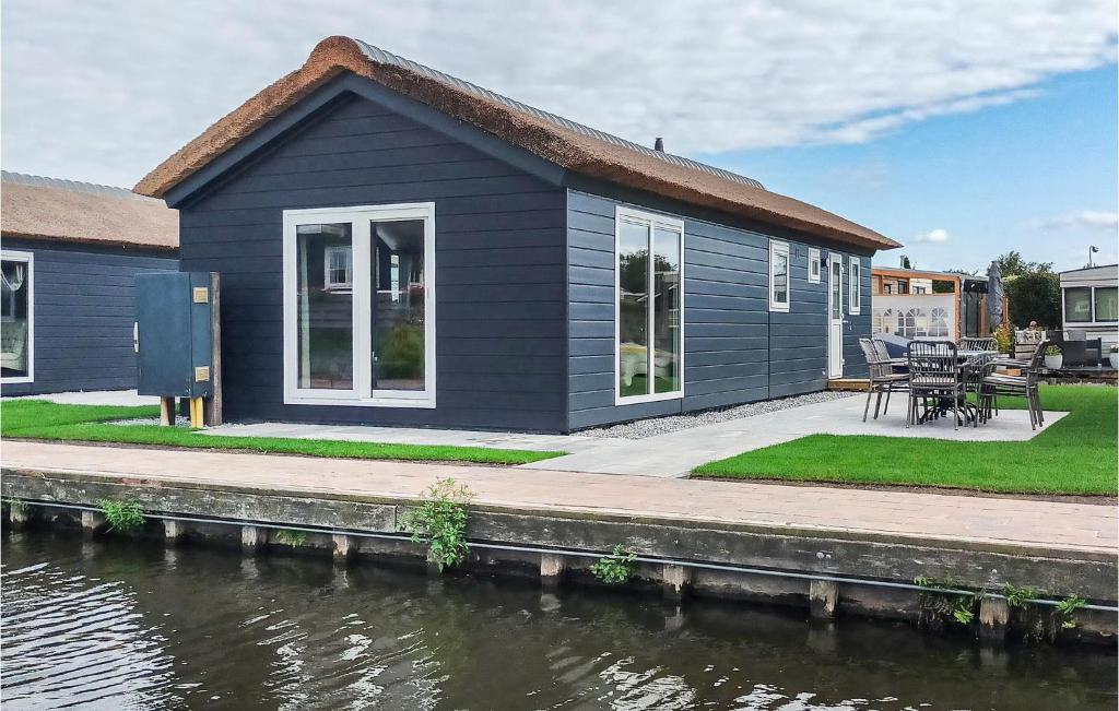 a blue house on the side of a river at Waterpark Giethoorn 2 in Giethoorn