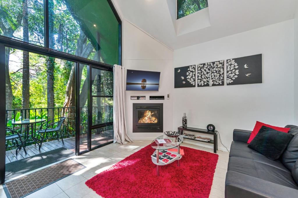 a living room with a couch and a fireplace at Linger a While Chalet on Gallery Walk with Spa, Fireplace, WiFi & Netflix in Mount Tamborine