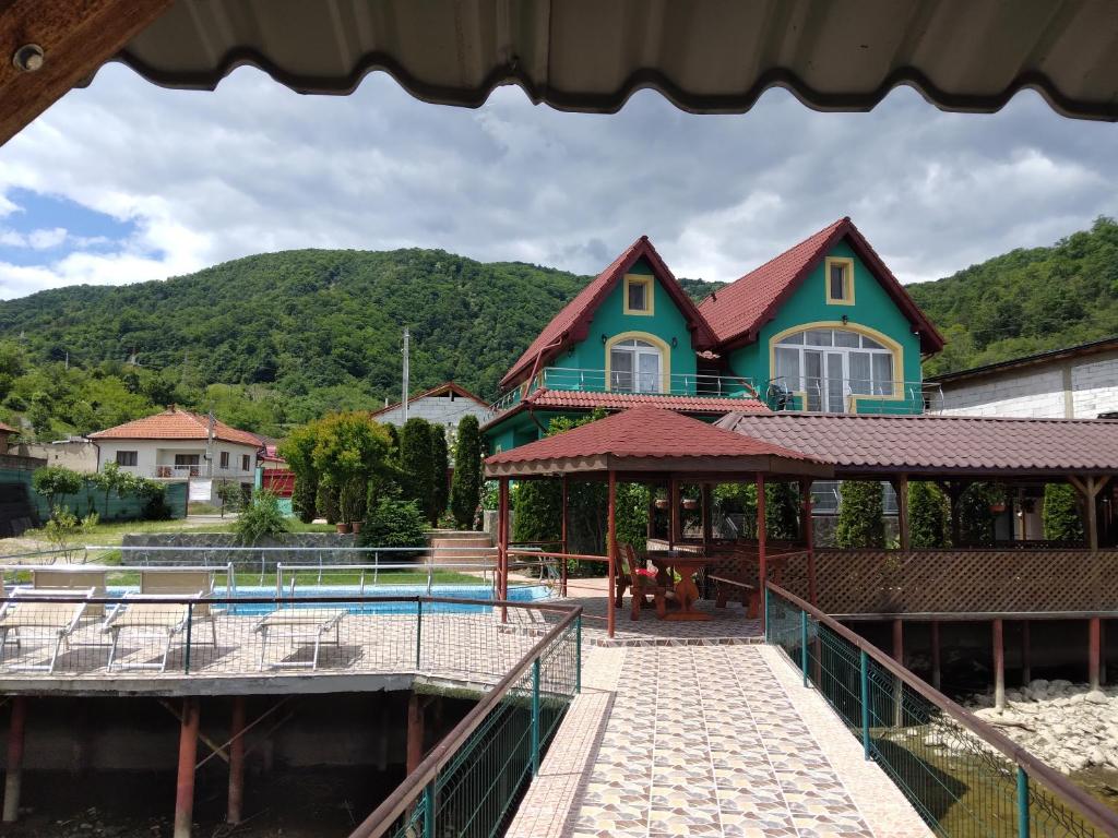 a house with a swimming pool in front of a house at Casa Lucian in Dubova