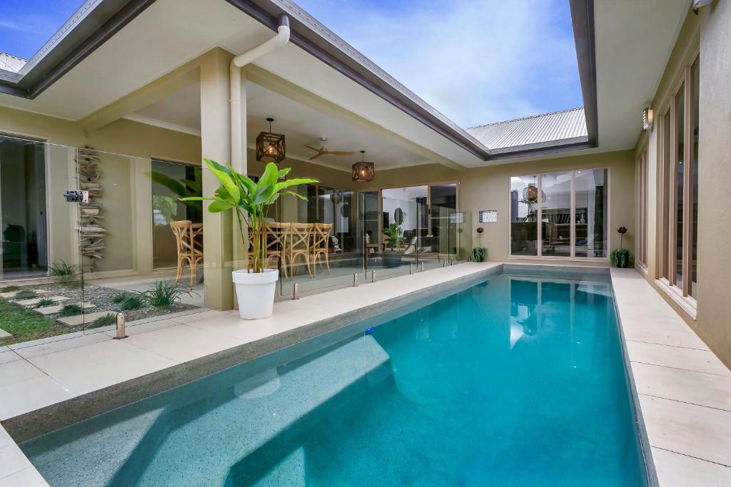 a swimming pool in a house with a patio at Escapades @ Palm Cove in Palm Cove