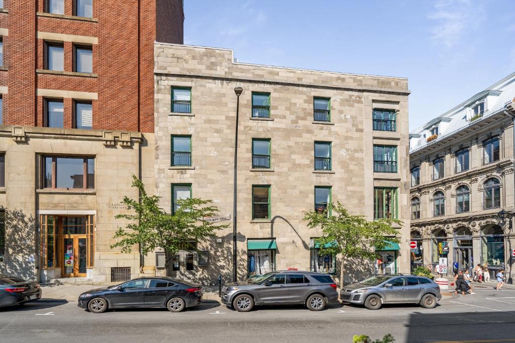 um grupo de carros estacionados em frente a um edifício em Le Nomade MTL em Montreal