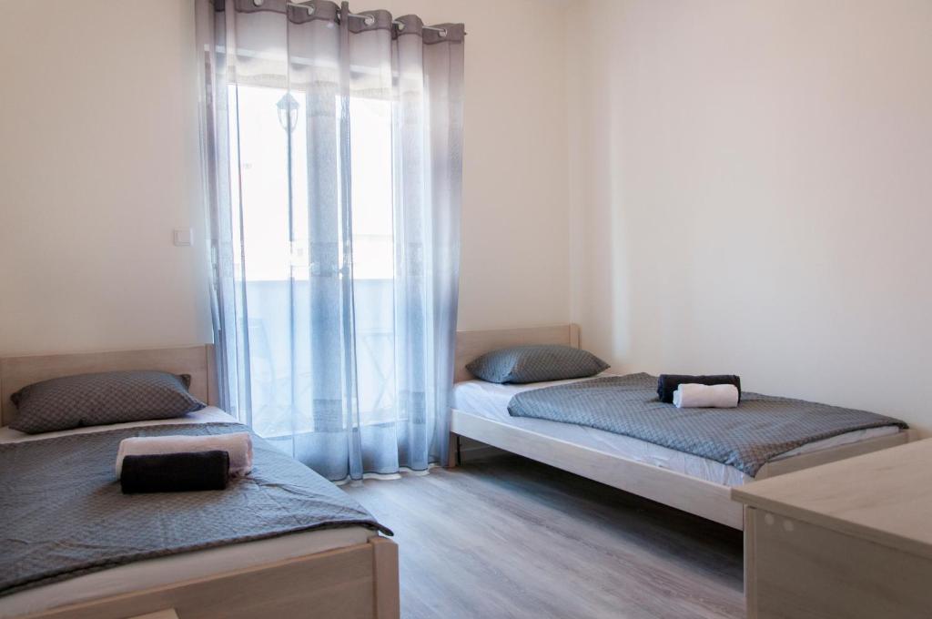 dwa łóżka w pokoju z oknem w obiekcie Domus Albus w mieście Zadar