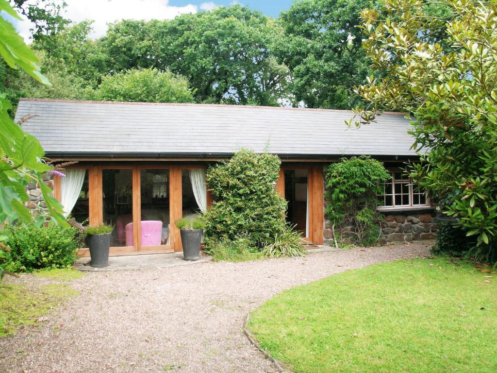 a small house with a garden and a yard at Oaktree Cottage in Appledore