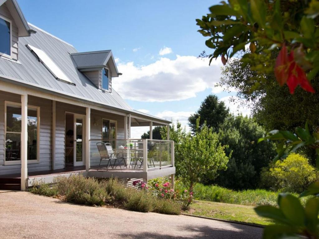 a house with a porch with a chair on it at Della Fonte in Daylesford