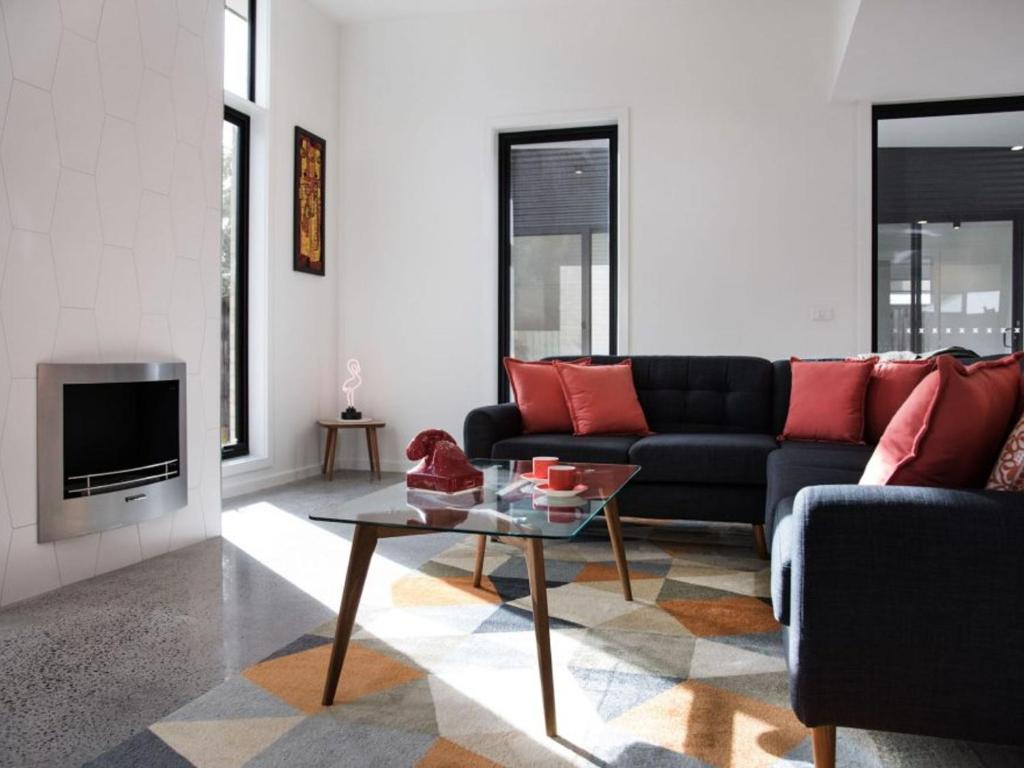 a living room with a couch and a table at Arenas North in Daylesford