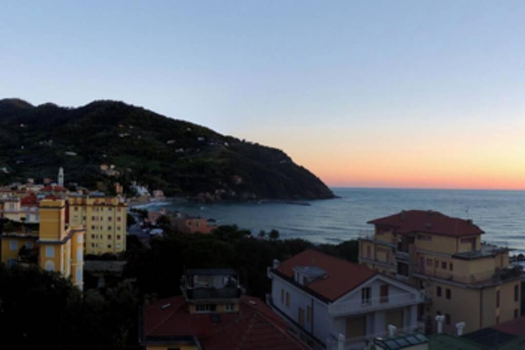 a view of a city and the ocean at sunset at splendido appartamento vista mare in Levanto