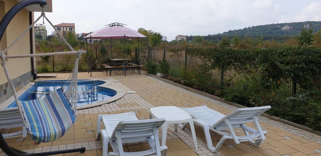 een patio met stoelen, een tafel en een zwembad bij Pearl Sunshine Appartments in Primorsko