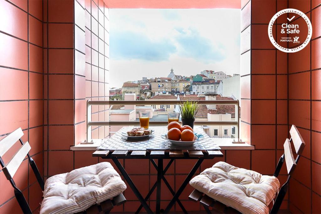 リスボンにあるModern Graca by Homingのバルコニーにテーブルとフルーツの盛り合わせ