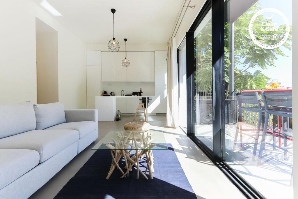 sala de estar con sofá y mesa de cristal en Avenida Premium by Homing en Lisboa