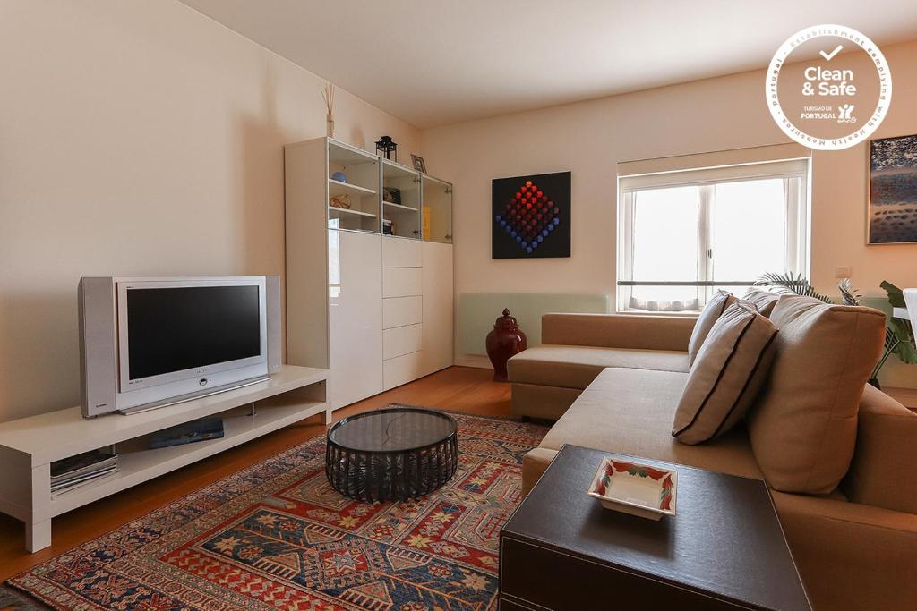 a living room with a couch and a tv at Downtown Chiado by Homing in Lisbon
