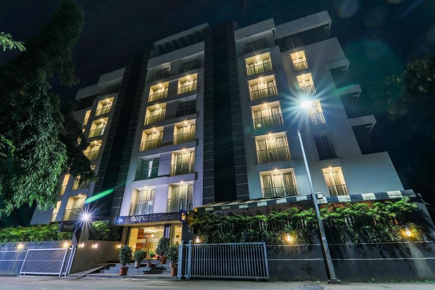 a building with lights in front of it at night at Magnus Star Residency in Pune