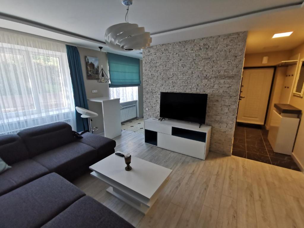 a living room with a couch and a flat screen tv at ALDO comfort in Ludza