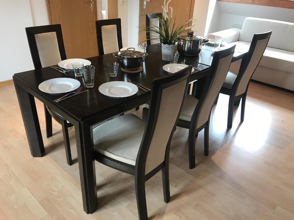 a black dining room table with chairs and plates on it at Franzi‘s-Ferien-Freizeit in Peißenberg