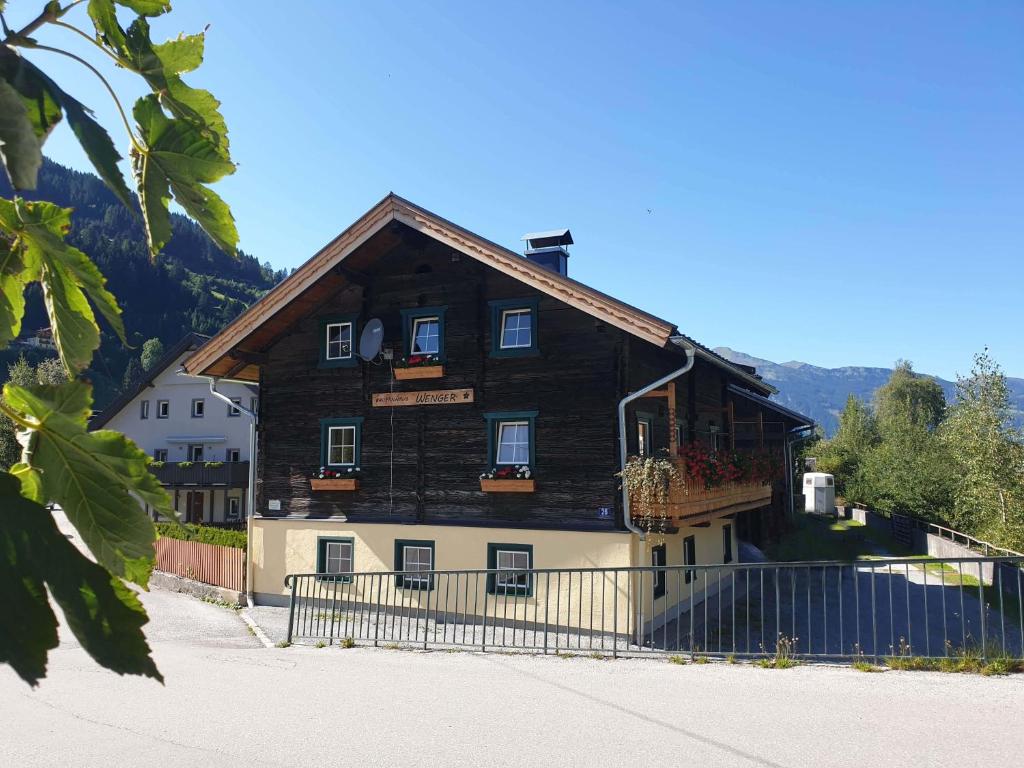 une grande maison en bois avec une clôture devant elle dans l'établissement Almliesl GAST-387, à Bad Gastein