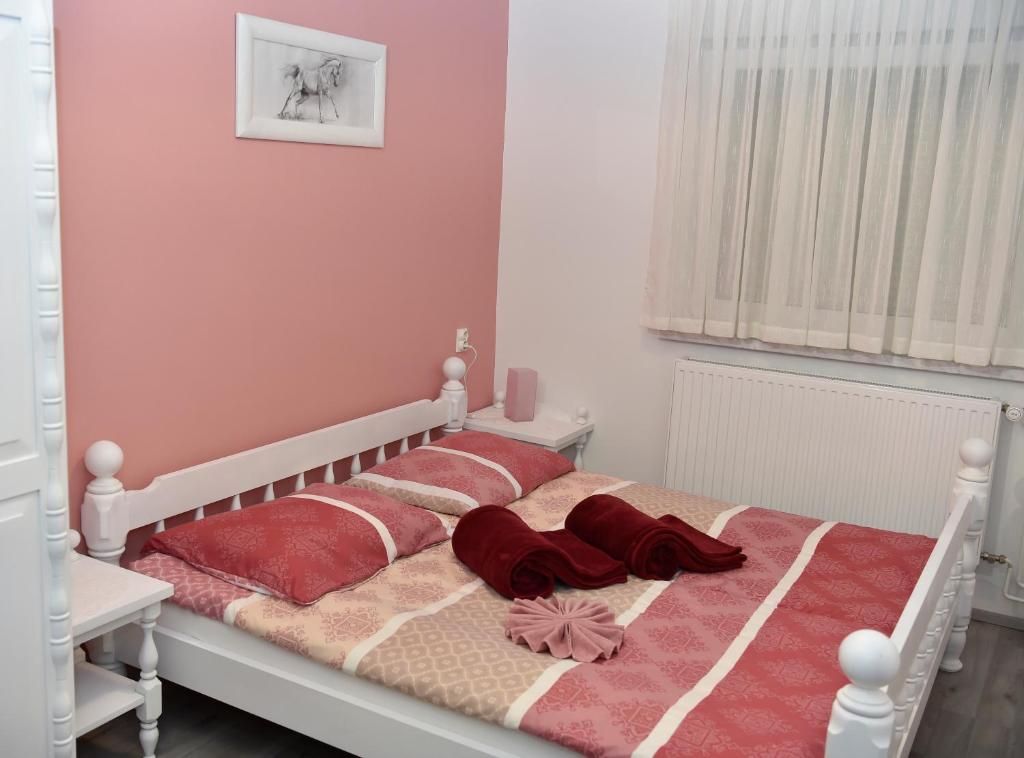 1 cama con almohadas rojas en el dormitorio en Gostišče Trobej, en Gornji Grad