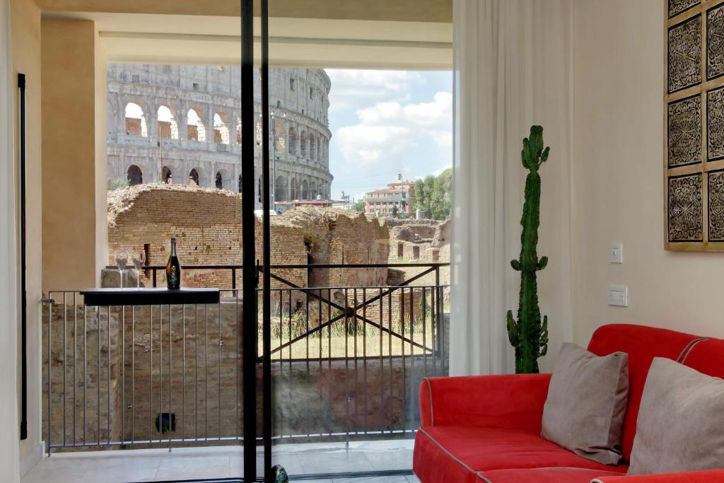 a living room with a red couch and the coliseum at Luxury Domus Apartment 1 in Rome