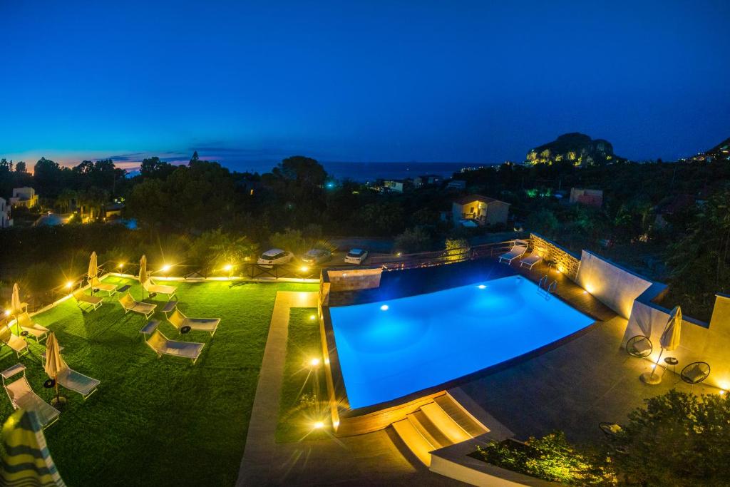a swimming pool in a yard at night at Pater Meus Suites in Cefalù