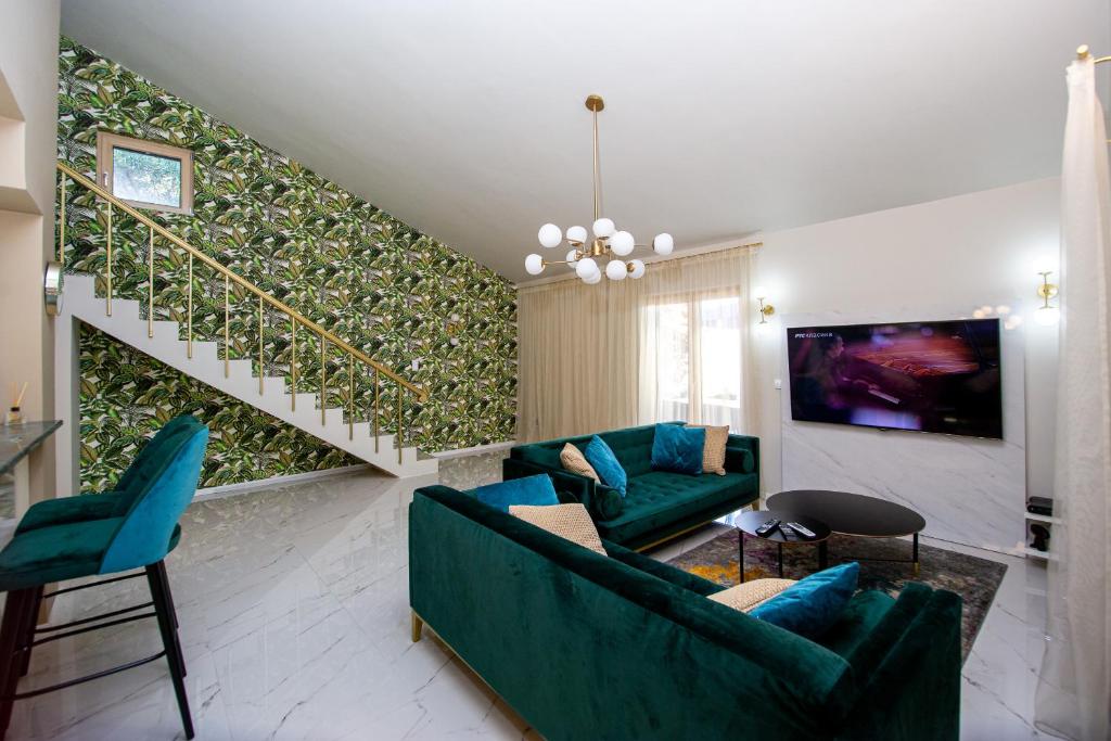 a living room with blue furniture and a green wall at Villa M&M in Budva