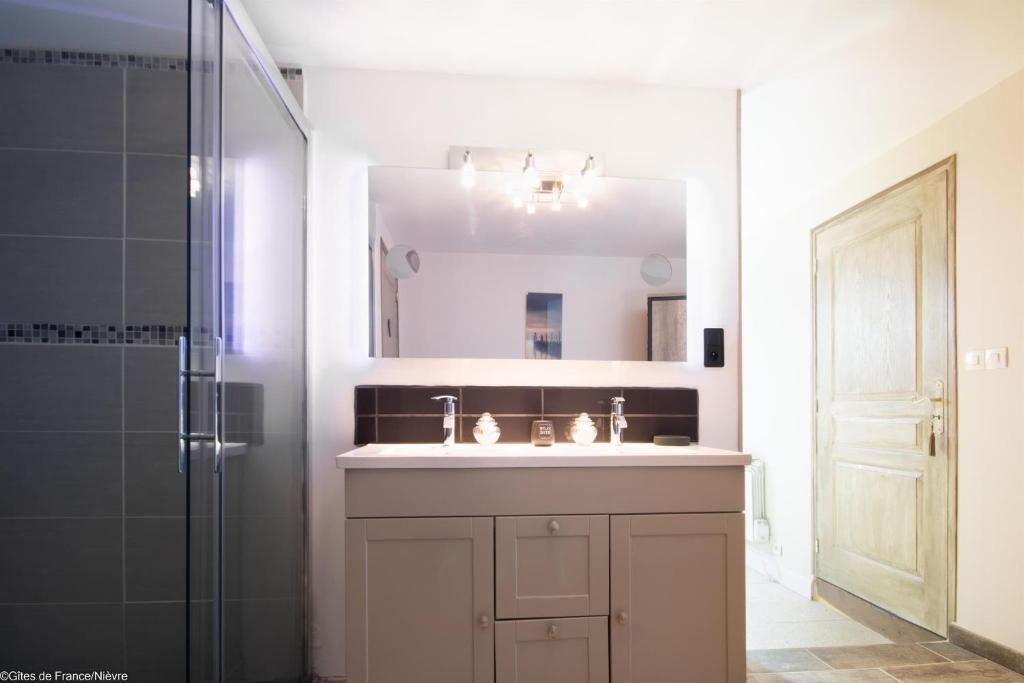 y baño con lavabo y ducha con espejo. en La Lisière du Morvan, en Magny-Lormes