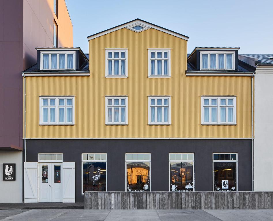 a large yellow building with white windows at Exeter Hotel in Reykjavík