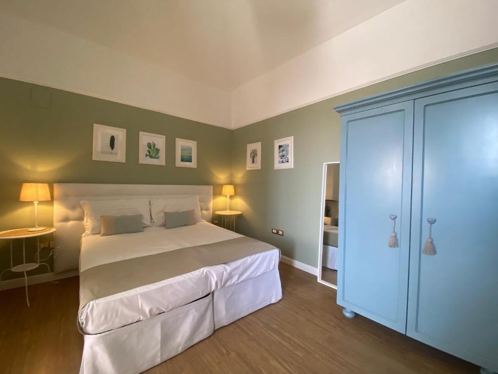una camera con un grande letto bianco e due lampade di Aduepassi apartments a Manfredonia