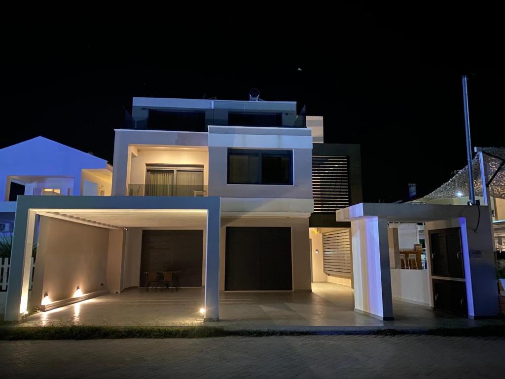 ein großes weißes Haus in der Nacht mit Lichtern in der Unterkunft Vit'S sea Villa in Siviri