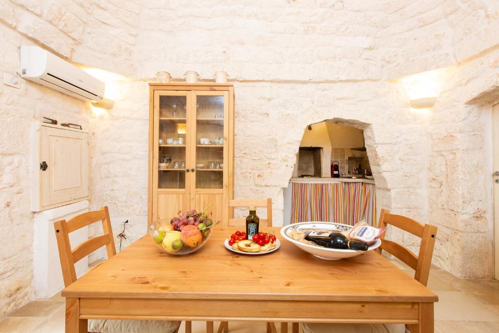a wooden table with a bowl of fruit on it at Lovely Stone House In Ostuni in Ostuni