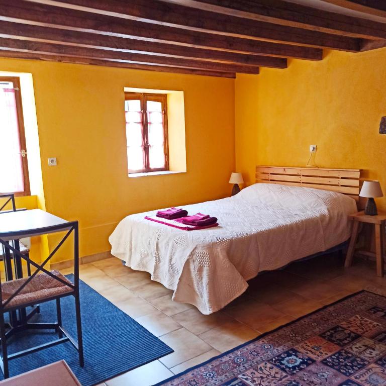 - une chambre avec un grand lit aux murs jaunes dans l'établissement STUDIO 