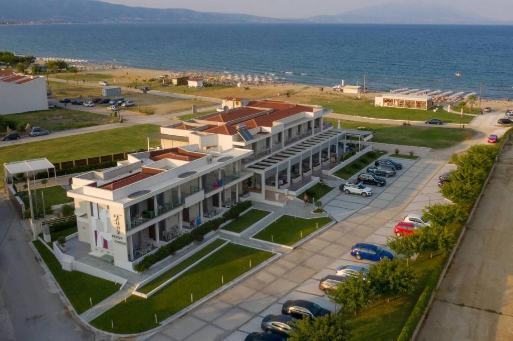 un gran edificio blanco con un aparcamiento junto al océano en Fani Luxury Boutique, en Stavros