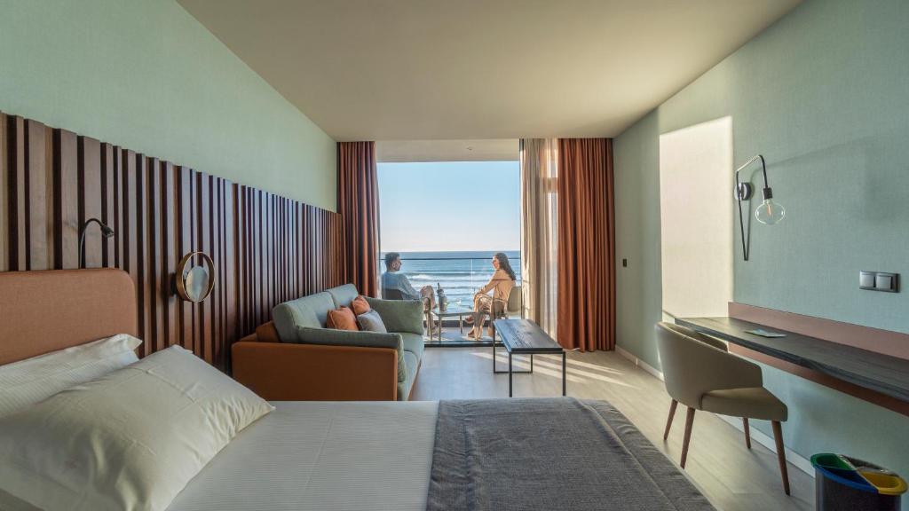 a hotel room with a bed and a view of the ocean at Hotel Verde Mar & SPA in Ribeira Grande