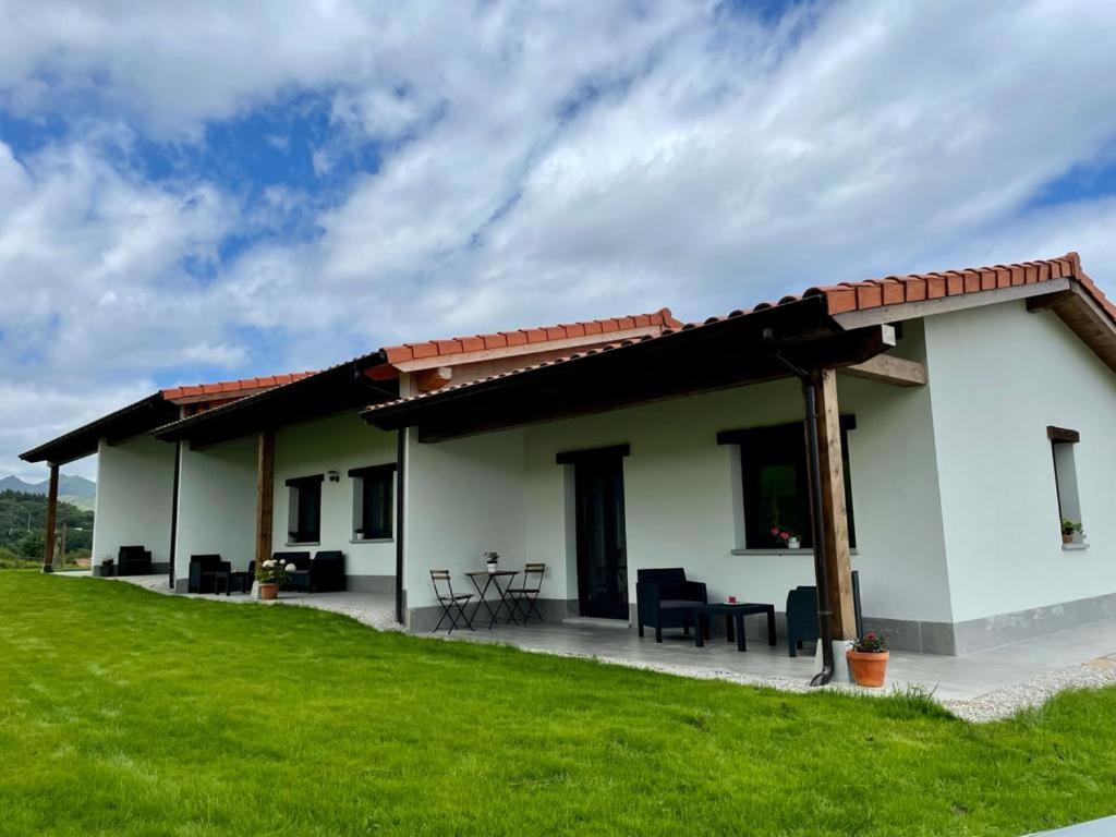 una casa bianca con patio e prato verde di APARTAMENTOS LOS MANZANOS a Ribadesella