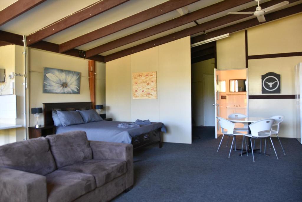 ein Schlafzimmer mit einem Bett, einem Sofa und einem Tisch in der Unterkunft The Studio in Middlemount