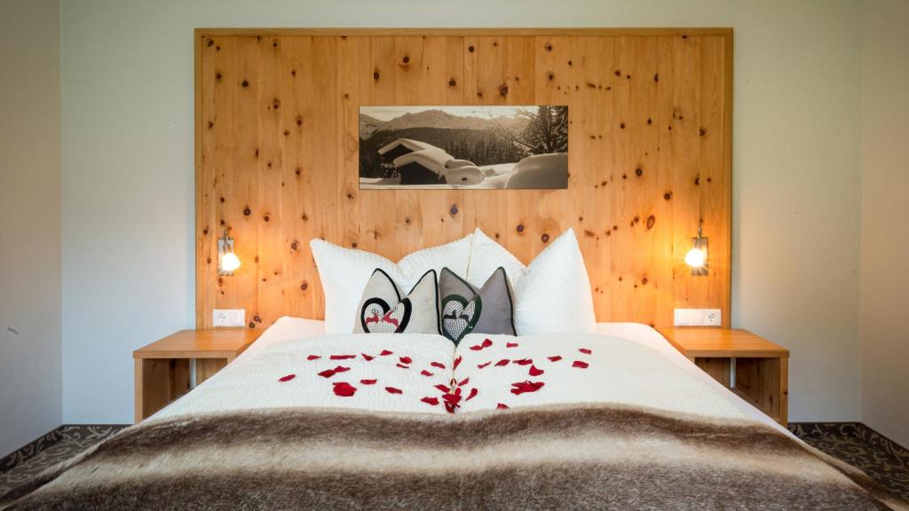 a bedroom with a large bed with red flowers on it at St. Lukas Apartments in See