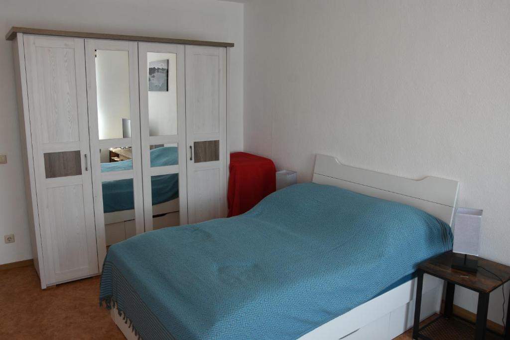 a small bedroom with a bed and a cabinet at Marktquartier in Reichenbach