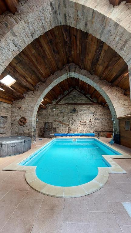 een groot zwembad in een stenen gebouw bij Gîtes la Molière Haute in Plaisance
